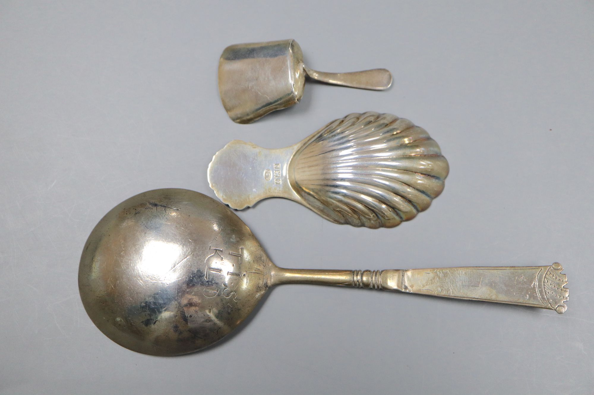 An early 18th century Dutch white metal spoon, the bowl underside monogrammed TIS-KLD and two silver caddy spoons.